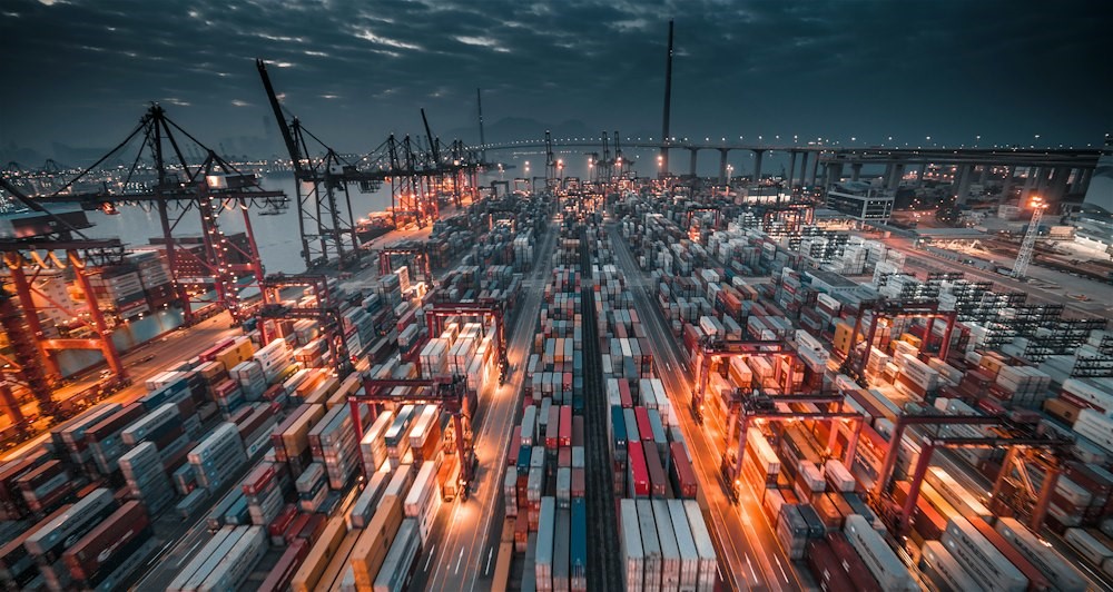 Container terminal at dusk showcasing IoT and GPS technology for smart logistics